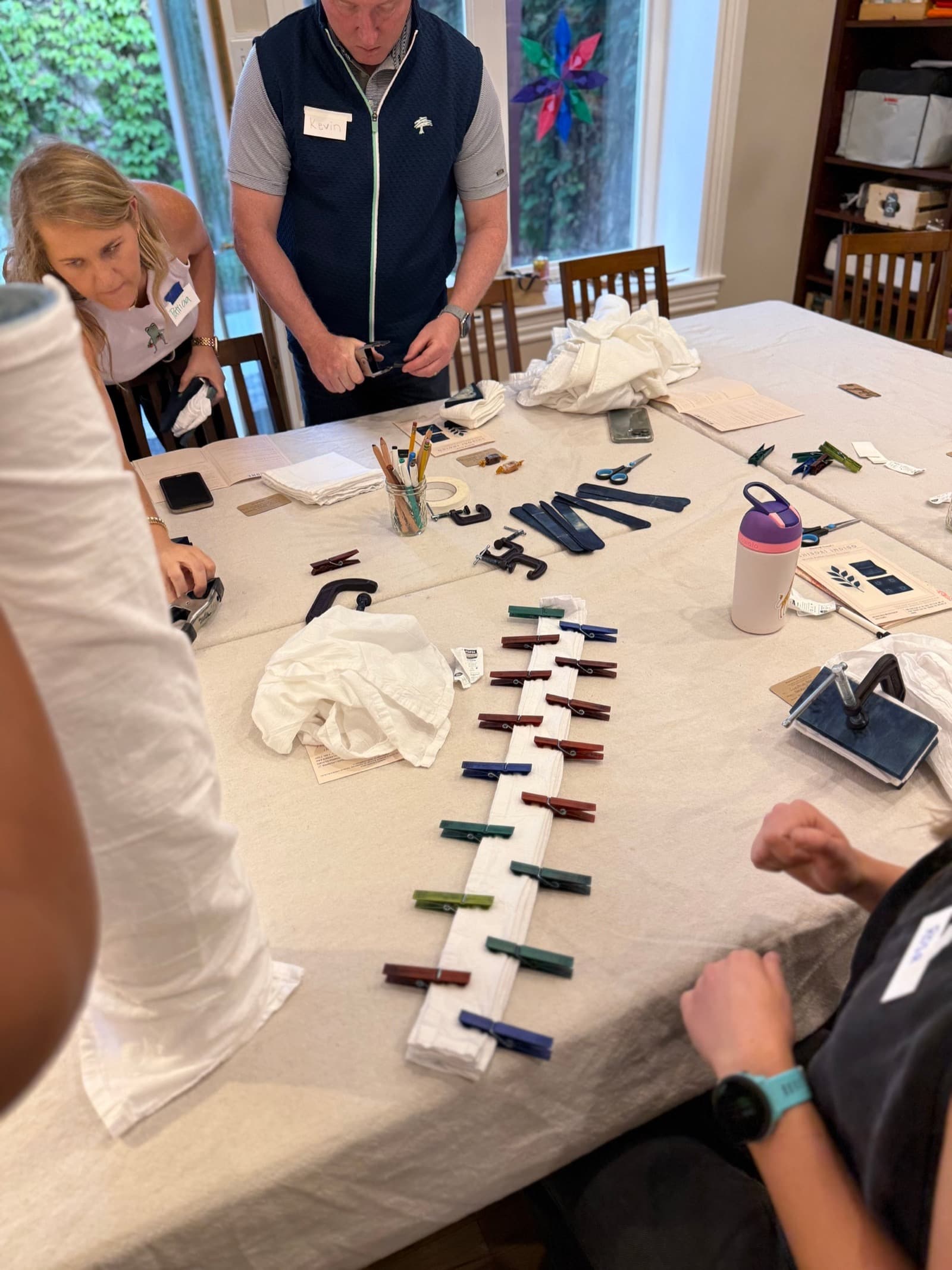 Adults folding and clipping fabric together during a Handcraft Revival workshop